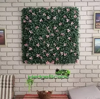 Pink-flowering wall panel: A square floral panel with pink blossoms is mounted on pale brick above a small decorative shelf.