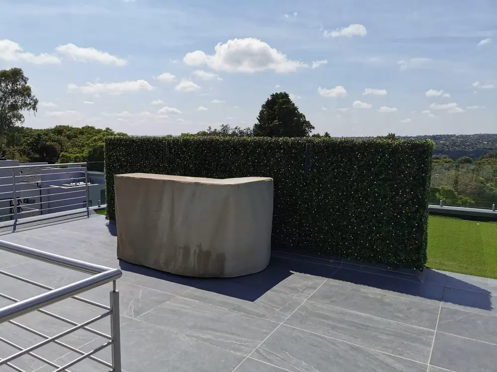 Rooftop utility screening: A tall hedge screen sits behind a rooftop service unit, reducing the visual impact of the exposed equipment.